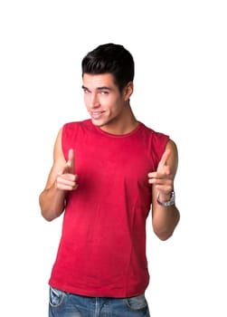 Portrait of Cool Smiling Young Man in Red Sleeveless Shirt and Jeans Pointing at Camera with Two Hands. Isolated on White Background.