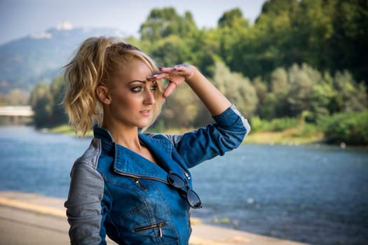 Young Pretty Blond Woman in Trendy Denim Fashion Outdoor Next to River and Park
