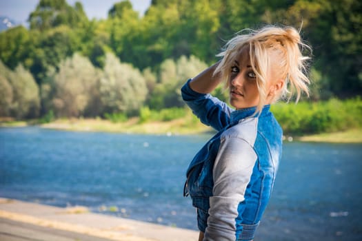Young Pretty Blond Woman in Trendy Denim Fashion Outdoor Next to River and Park