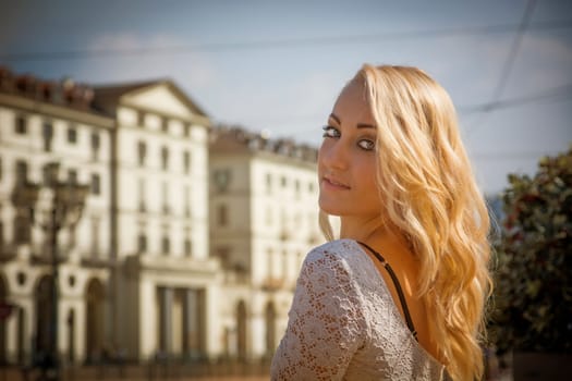 Pretty Young Blonde Woman in Sexy White Dress in Turin City Center, Italy. Captured with Architectural Buildings at the Back.