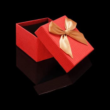 Gift box open paper texture red with a bow on a black glossy background with real reflection. Isolated.