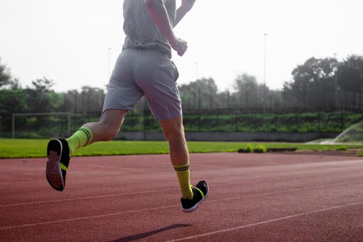 The runner is running at the stadium.