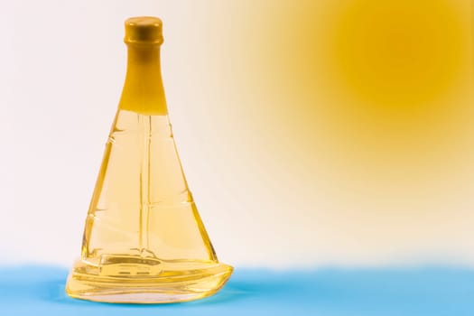 Ship shape from bottle of alcohol on sea and sun background.