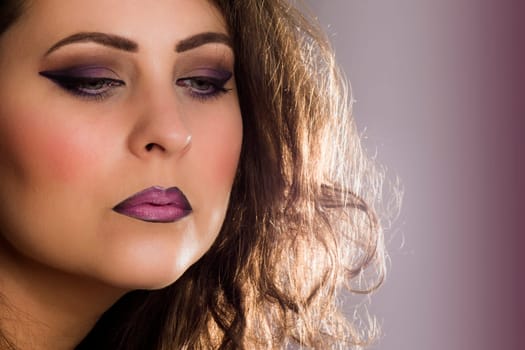 Retro beauty portrait with purple make-up on purple background.