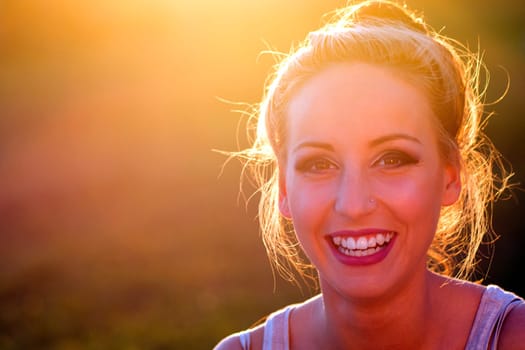Happy laughing young woman outdoors at sunlight.