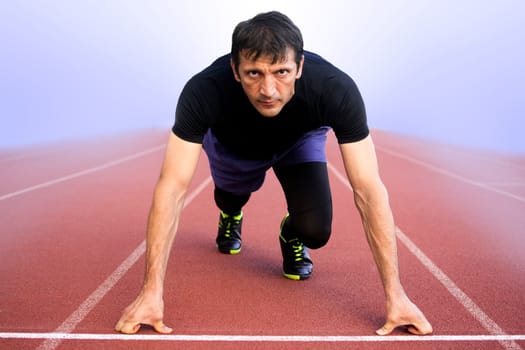 The athlete is ready to run on startline in the fog.