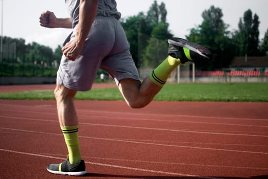 The athlete is running in the stadium.