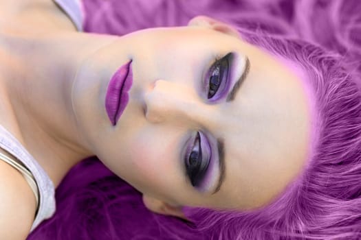 Beauty portrait of woman with purple hair and make-up.