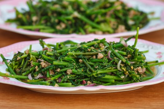 Vegetable fern spicy salad on wooden background