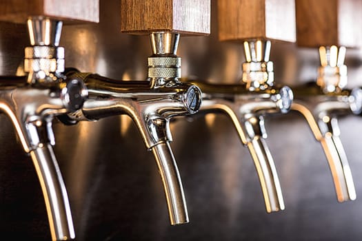 The beer taps in a pub. nobody. Selective focus