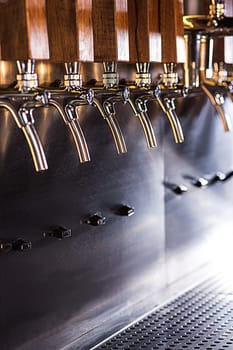 The beer taps in a pub. nobody. Selective focus
