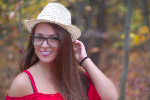 woman smiling hat red dress eyeglasses portrait outdoor autumn forest