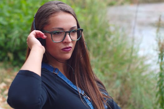 women headphones outside lake water young pretty student girl green park listening music