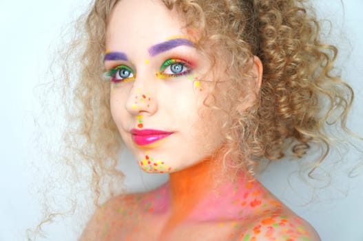 young blonde woman with curls,make-up in rainbow colors,portrait