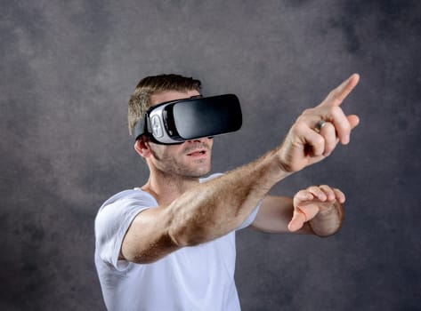 young man with virtual reality glasses pointing upward