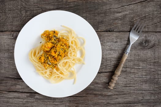 Spaghetthi with pesto from pumpkin and Parmesan on rustic table
