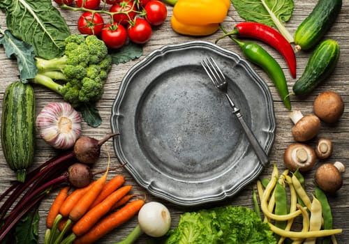 Various of fresh vegetables and ingredients with plate on wooden background. Healthy diet food concept
