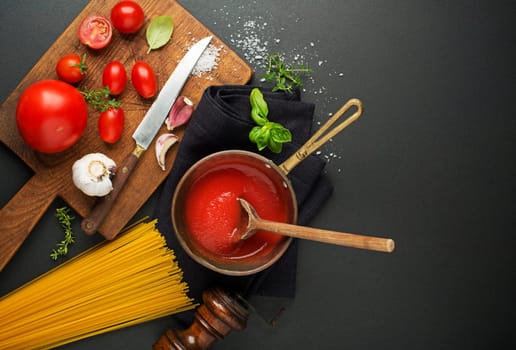 Fresh ingredients for cooking pasta on black background place for text. Vegan food vegetarian and healthy cooking concept.