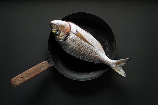 Delicious fresh fish on dark vintage background. Healthy food, diet or cooking concept