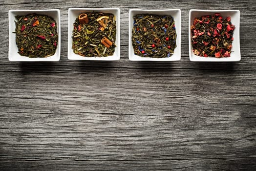 Dry tea collection of different types on wooden background