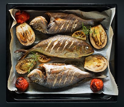 Grilled Gilt-head bream fish with lemon, herbs, oil, vegetables and spices