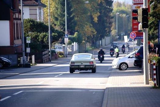 Taunusstein-Wehen,Germany - October 15,2017: Road traffic with a Ford Mustang and a group of motorcycles on Berliner Straße on October 15,2017 in Taunusstein-Wehen.