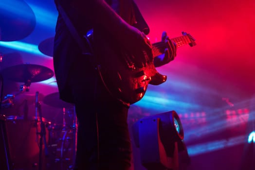 Guitar in the hands of a musician on a rock concert music