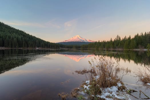 Alpenglow sunset over Mount Hood at Frozen Trillium Lake in Winter