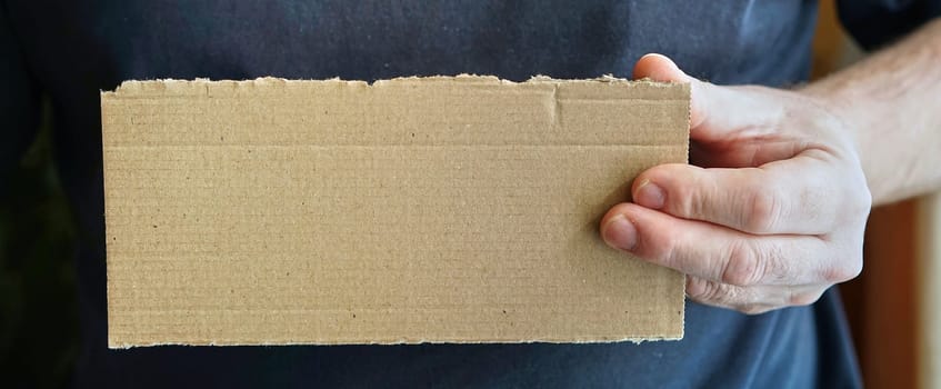 empty cardboard sign in a person's hand