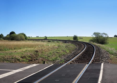Empty track leading to the horizon with blue sky