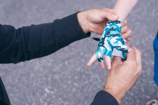 A young coach tying boxing bandages to a child's pupil. children's boxing. Blurred background. horizontal.