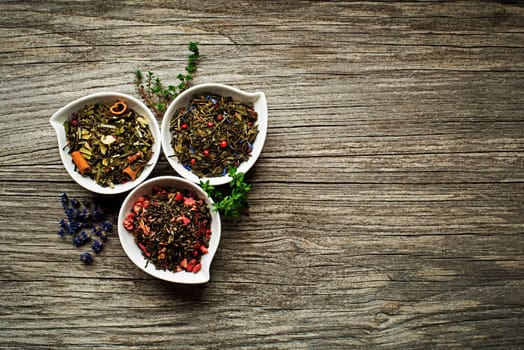 Dry tea collection of different types on wooden background
