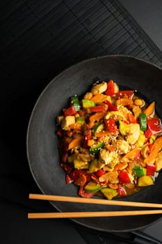 Chinese food with meat and vegetables on black background