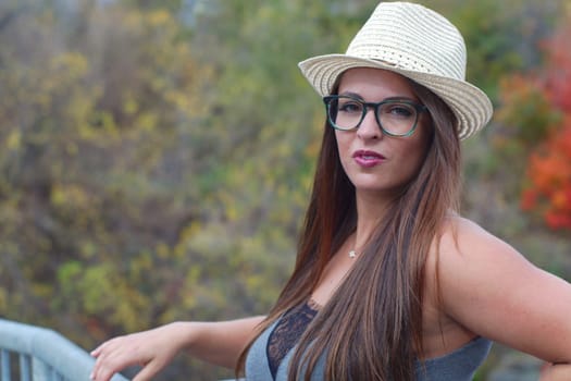 young women around tweny wearing straw hat and glasses outdoor portrait