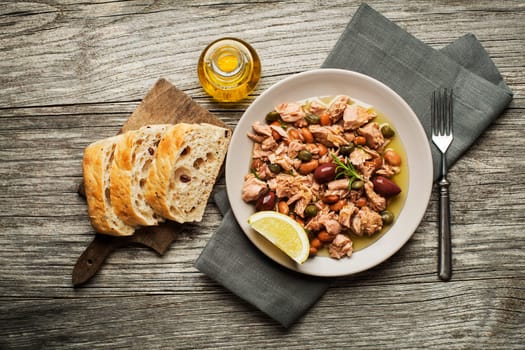 Tuna salad with beans and olive oil on wooden table