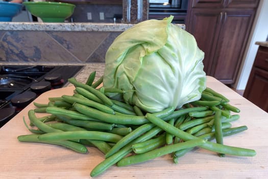 Head of Cabbage and String Beans on Chopping Board by Kitchen Cooking Stove Top