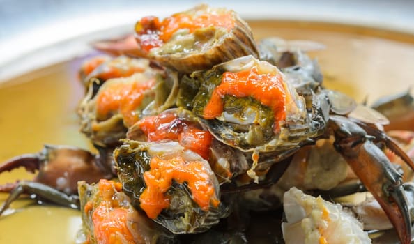 Fresh raw female crab marinated in fish sauce on stainless steel serving tray. Thai street food.