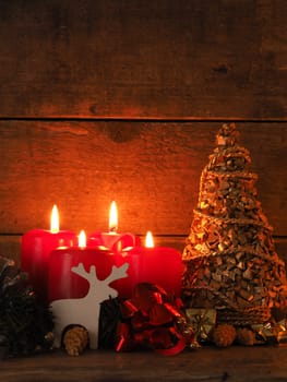 Romantic Christmas background with four burning candles on a wooden table