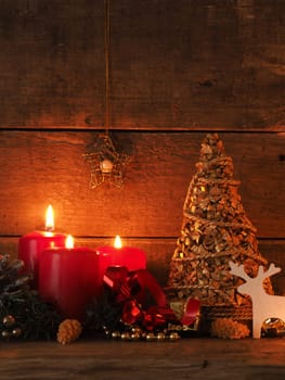 Romantic Christmas background with three burning candles on a wooden table
