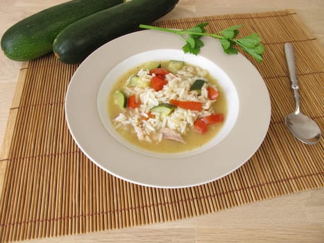 Homemade chicken soup with zucchini and tomatoes
