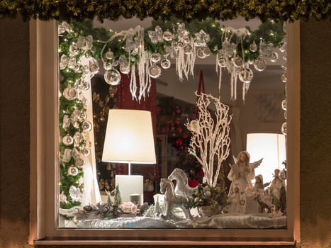 Weilheim, Germany - November 26, 2015: European Christmas shop window decoration with traditional porcelain figurine toys and balls