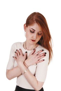 A beautiful young woman in a beige sweater and long brunette hair.holding her hands on her chest isolated for white background.