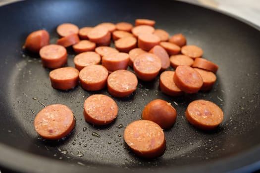 Close-up of Debrezinger sausage in frying pan with oil and fat