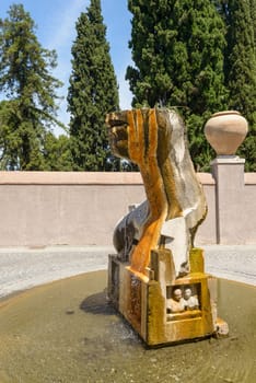 A fountain depicting a head, in a public square in Tivoli, Italy