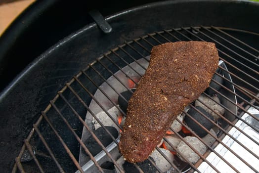 starting to grilling a big piece of beef meat in barbecue