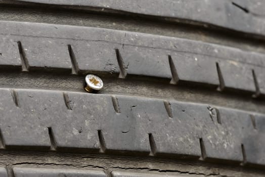 A flat tire by a little long screw