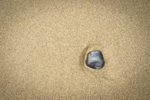 a black stone on the sand