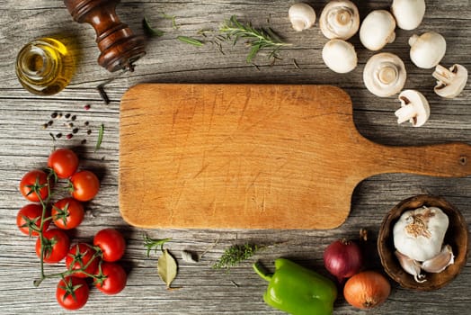 Mushrooms champignons and tomatoes with fresh ingredients on wooden background