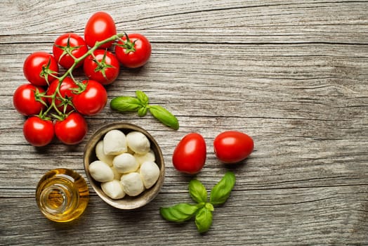 Fresh tomatoes and mozzarella cheese on wooden background. Top view