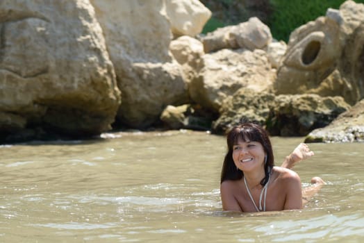 nice happy girl playing in the sea between the waves